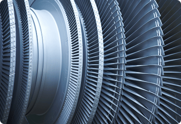 Close-up view of a metallic industrial turbine or jet engine component, showcasing detailed fan blades and circular structures.