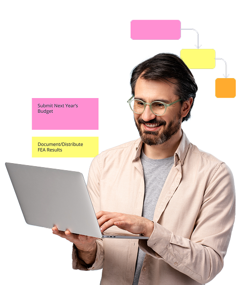 A smiling man with glasses and a beard is using a laptop. Around him are colorful visual elements representing workflow or task management, including labeled boxes such as “Submit Next Year’s Budget” (in pink) and “Document/Distribute FEA Results” (in yellow), and a flowchart above his head showing connected pink, yellow, and orange boxes with arrows. A smiling man with glasses and a beard is using a laptop. Around him are colorful visual elements representing workflow or task management, including labeled boxes such as “Submit Next Year’s Budget” (in pink) and “Document/Distribute FEA Results” (in yellow), and a flowchart above his head showing connected pink, yellow, and orange boxes with arrows.